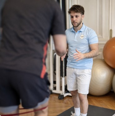 Nathan Touati guide un exercice de renforcement avec un élastique.